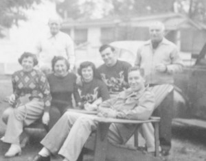 Normie and his wife, Wini, in matching sweaters in the center. My grandfather stands behind my grandma. Wini's parents are the women sitting on the left and the man standing on the right. At the bungalows in the Catskills in the 1950s.